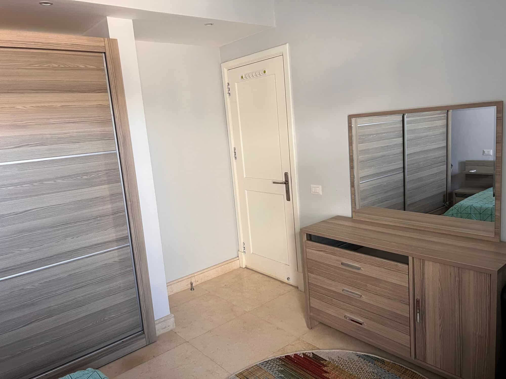 Spacious bedroom featuring a large wardrobe and matching dresser, ideal for comfortable living space.