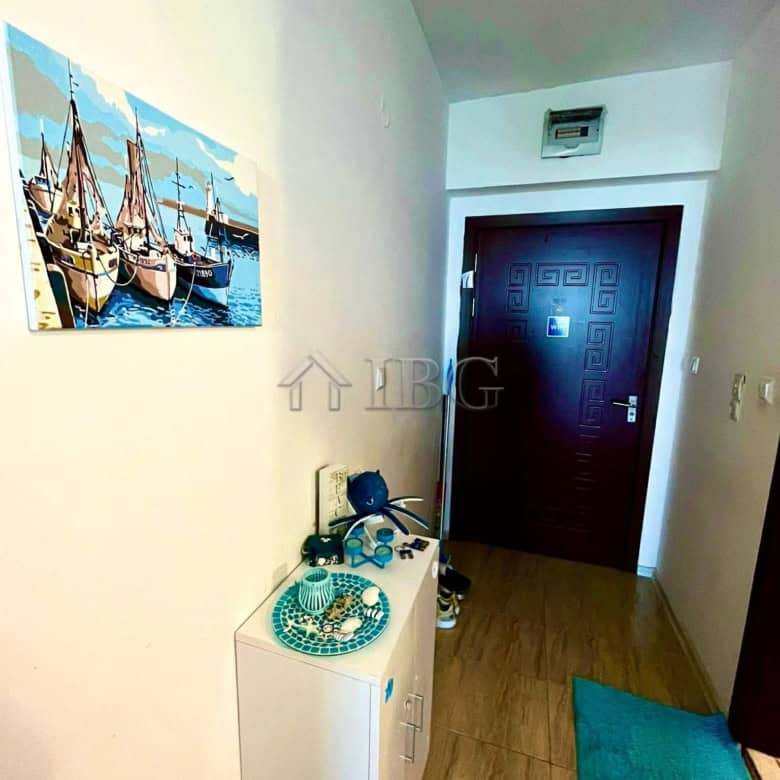 Interior view of a studio apartment with balcony in Ravda, showcasing modern decor and entry door.