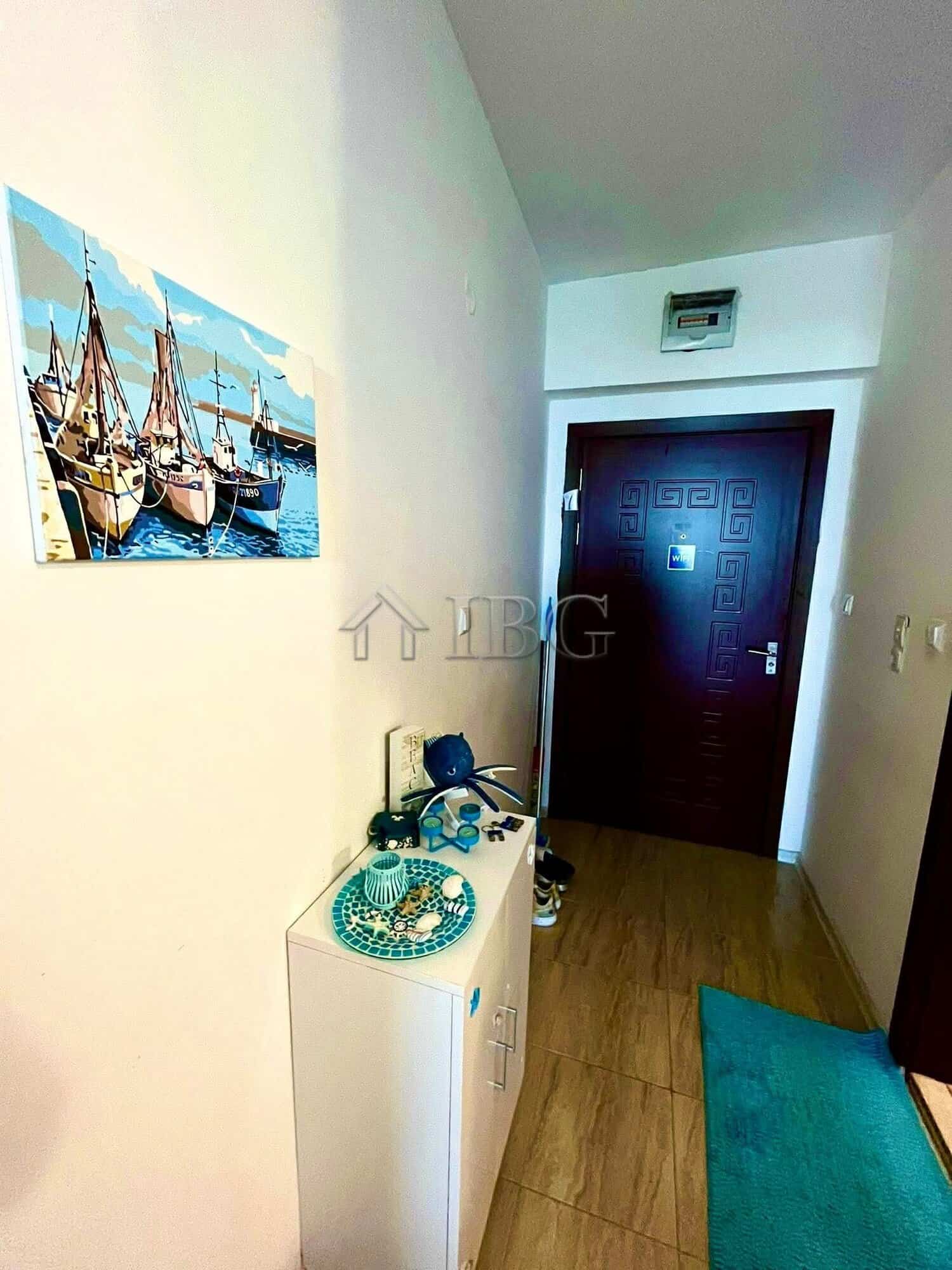 Interior view of a studio apartment with balcony in Ravda, showcasing modern decor and entry door.