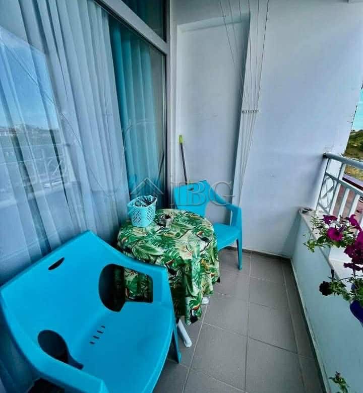 Small balcony with seating and flowers, overlooking the garden.