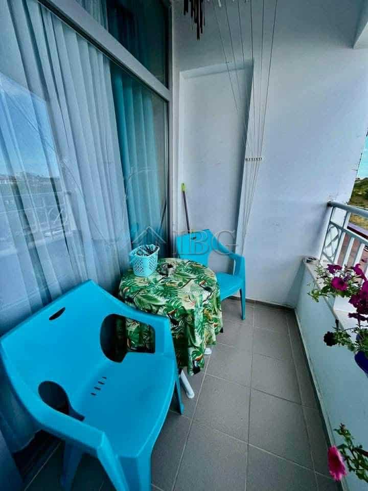 Small balcony with seating and flowers, overlooking the garden.