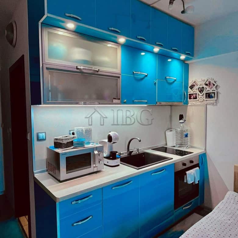 Bright kitchen with modern appliances and blue cabinets.