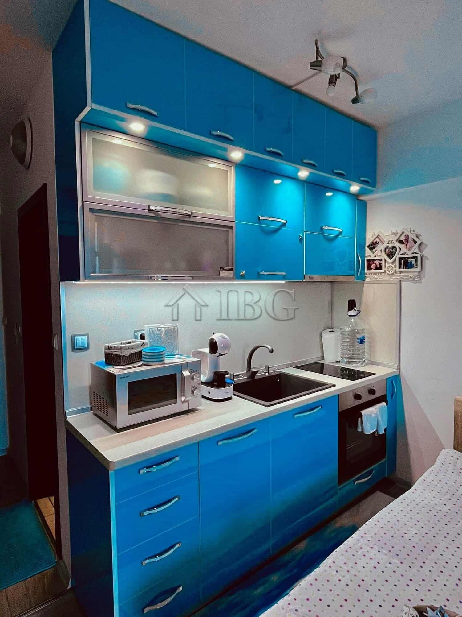 Bright kitchen with modern appliances and blue cabinets.
