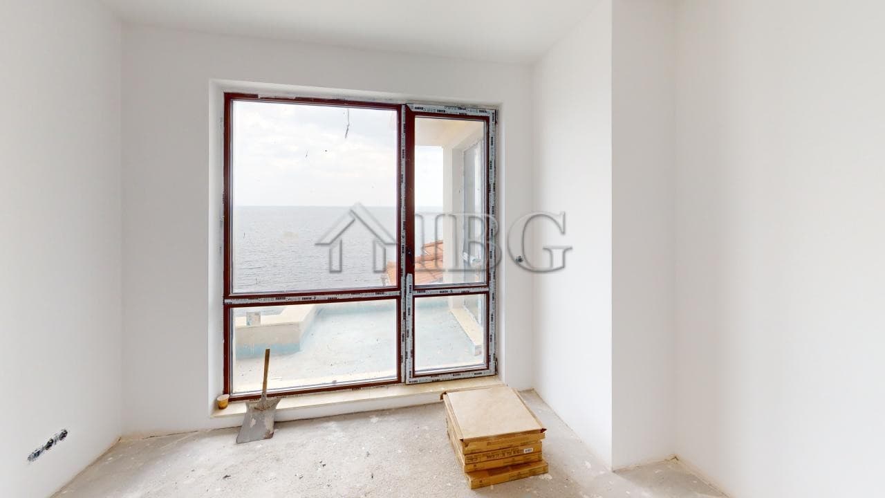 Bright room with large sea view window in a new apartment under construction.