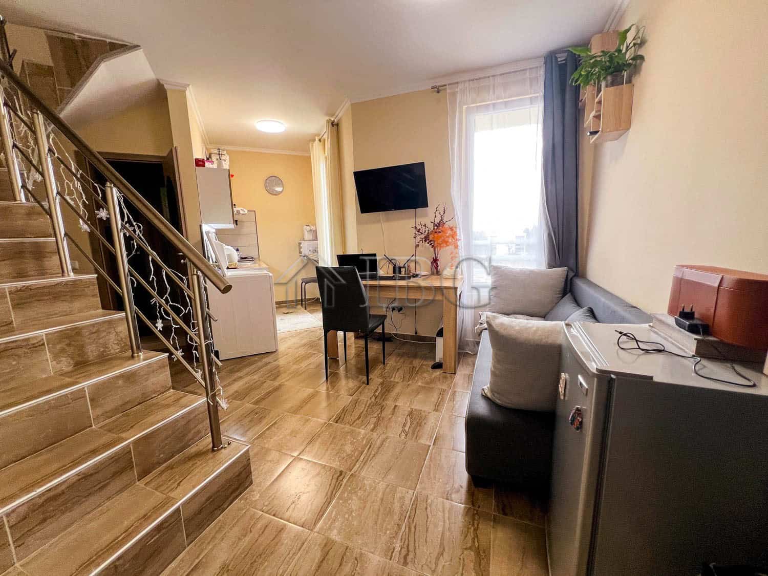 Modern 1-bedroom apartment with pool view in Sunny Beach, featuring a living area and balcony.