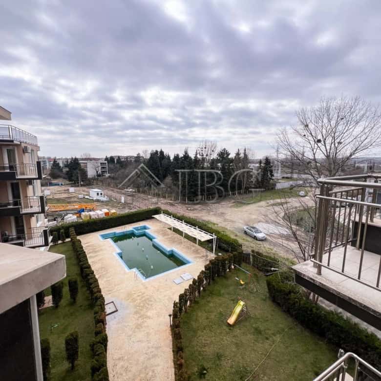 Apartment with pool view and balcony in a sunny beach location.