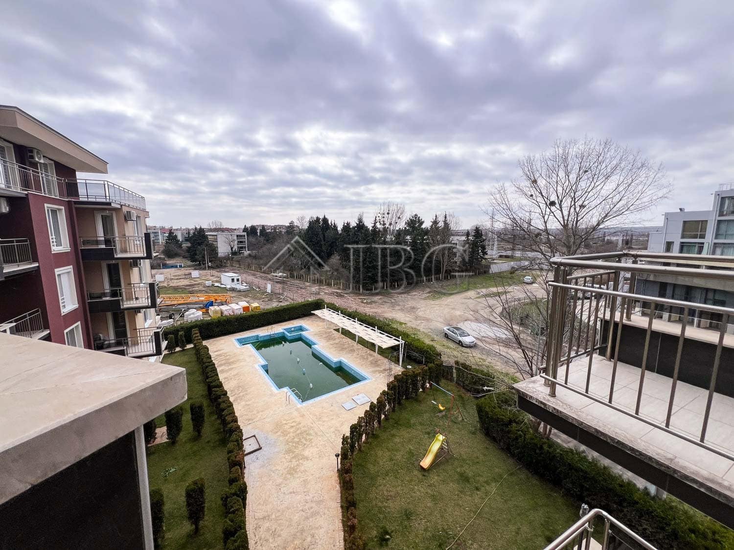 Apartment with pool view and balcony in a sunny beach location.