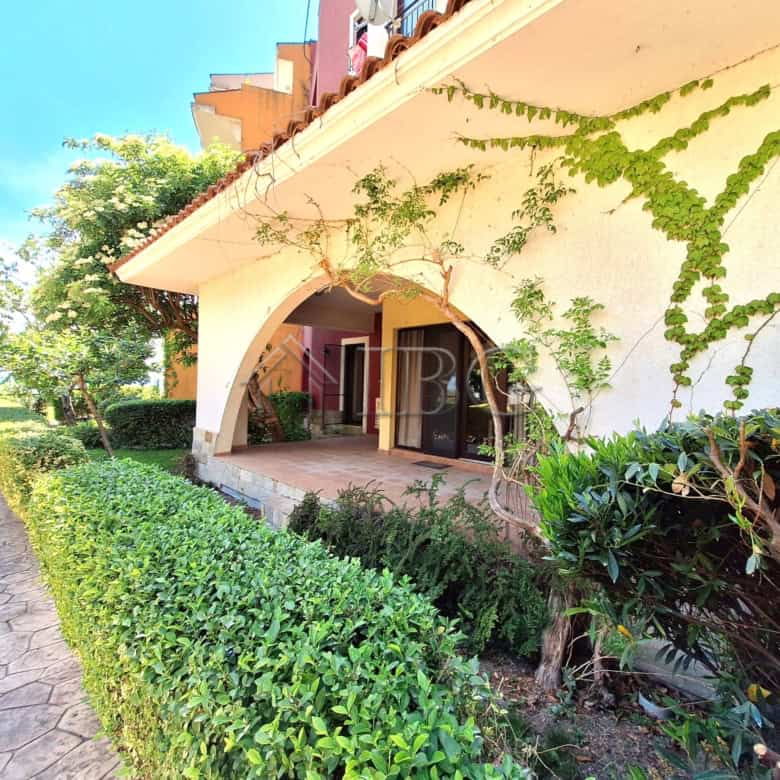 Charming apartment with veranda and lush garden in a beachfront complex.
