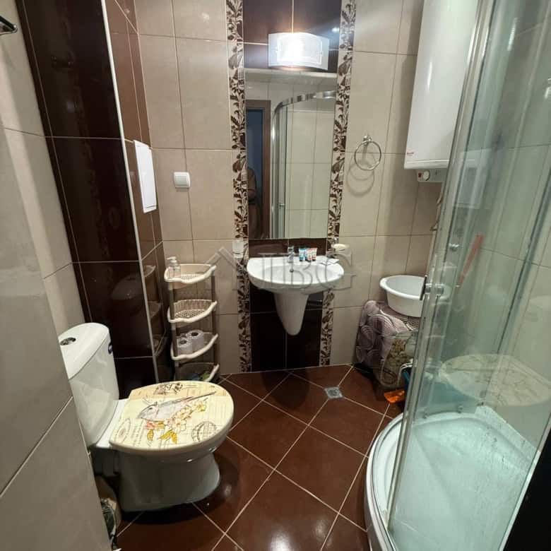 Bright bathroom with modern fixtures and shower cabin in Sea Diamond apartment.
