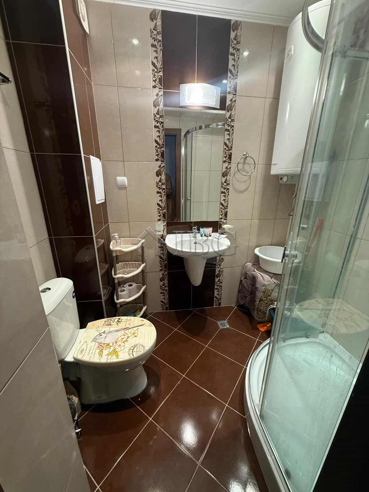 Bright bathroom with modern fixtures and shower cabin in Sea Diamond apartment.