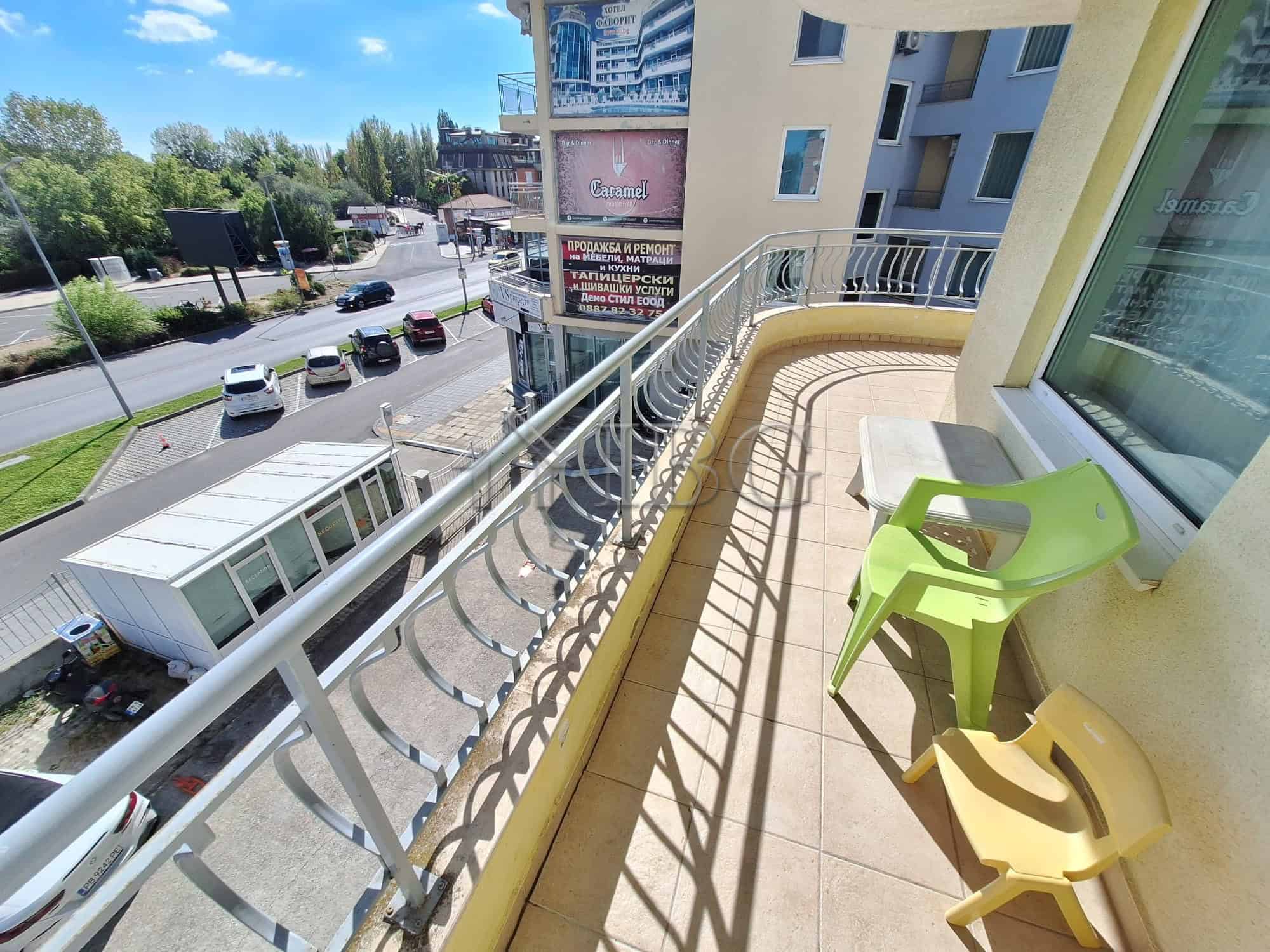 Balcony with two colorful chairs overlooking Sunny Beach streets and surrounding buildings.