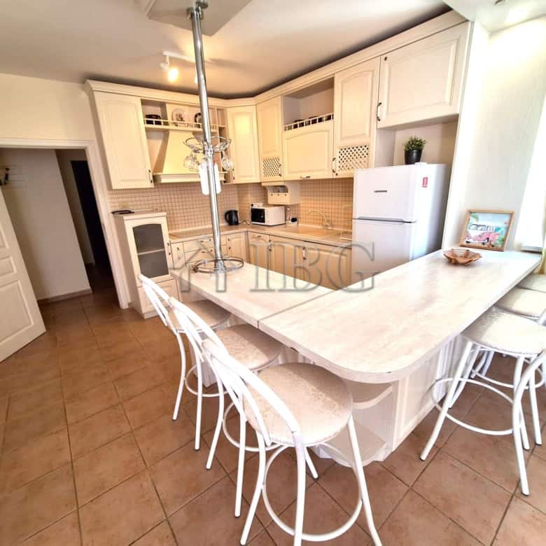 Bright kitchen with white cabinets, breakfast bar, and seating for family meals.
