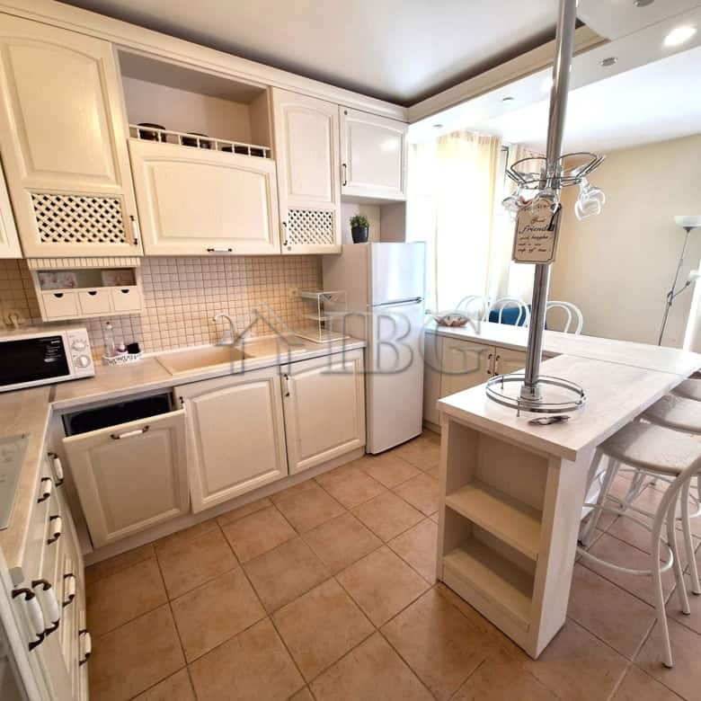 Spacious kitchen with white cabinets and modern appliances in Breeze complex, Sunny Beach.