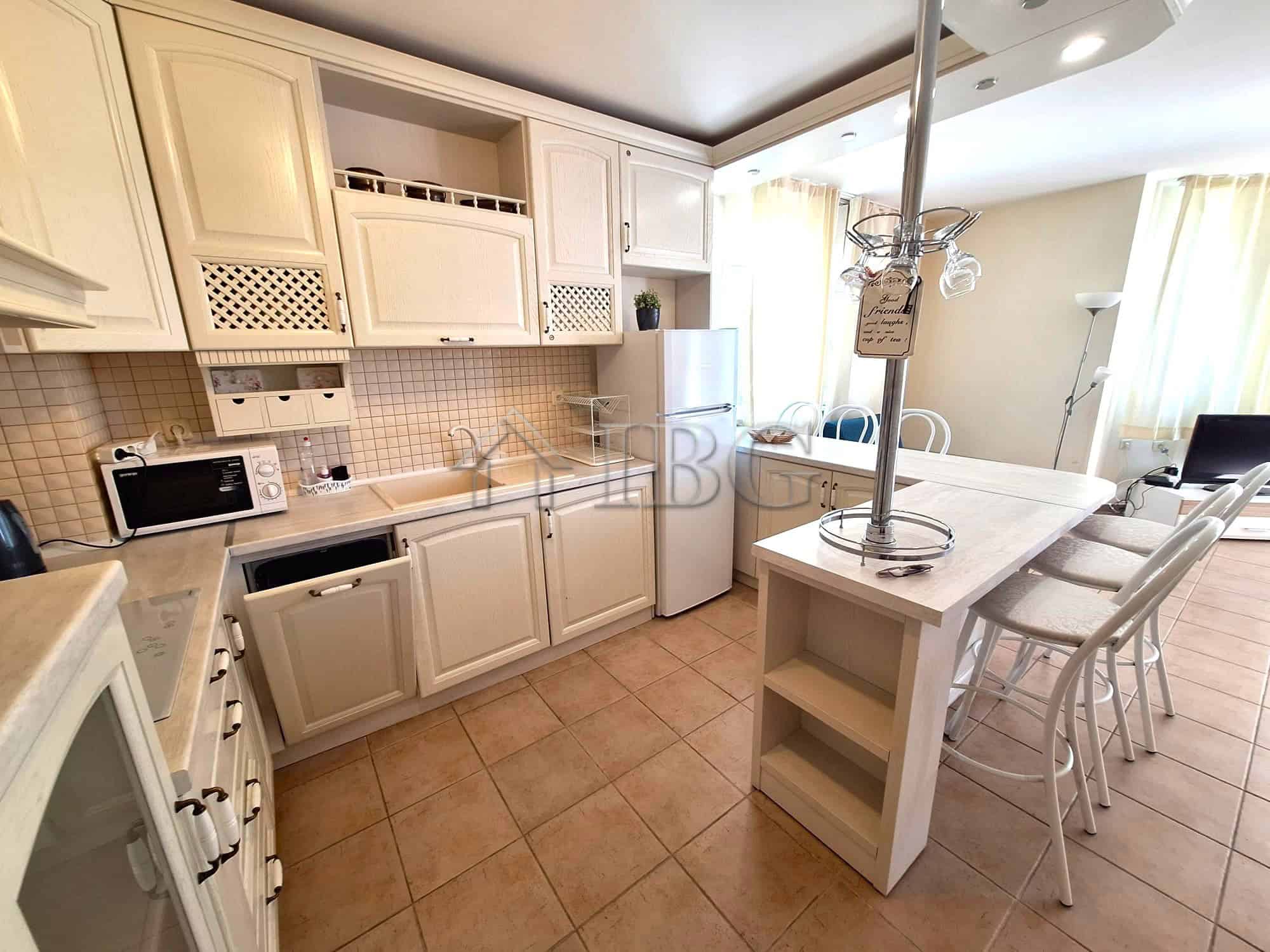 Spacious kitchen with white cabinets and modern appliances in Breeze complex, Sunny Beach.