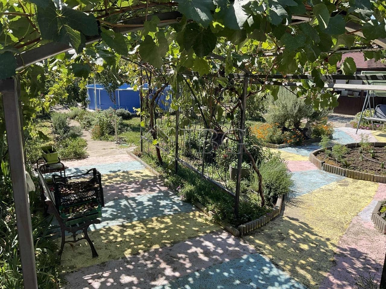 Beautiful garden space with seating and shaded areas near a renovated house.