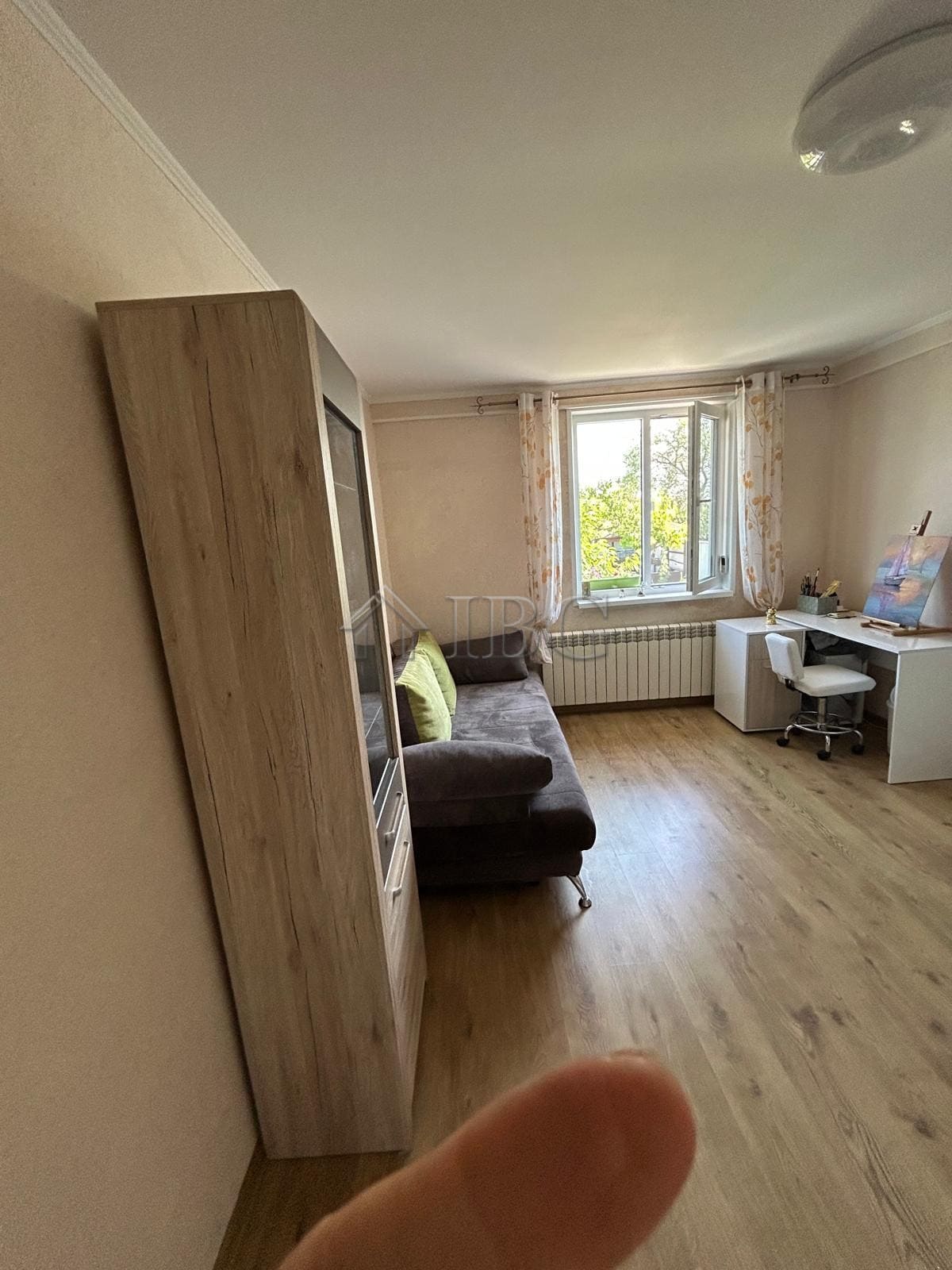 Living room with sofa and desk near window in renovated house.