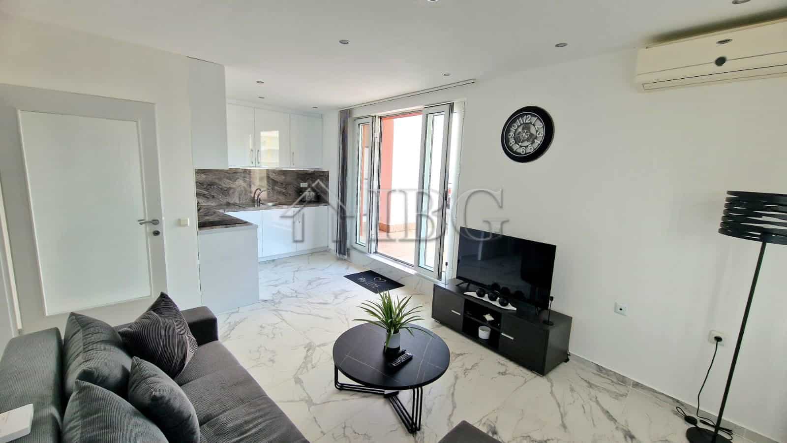 Bright living room with sea view, balcony access, and contemporary decor.