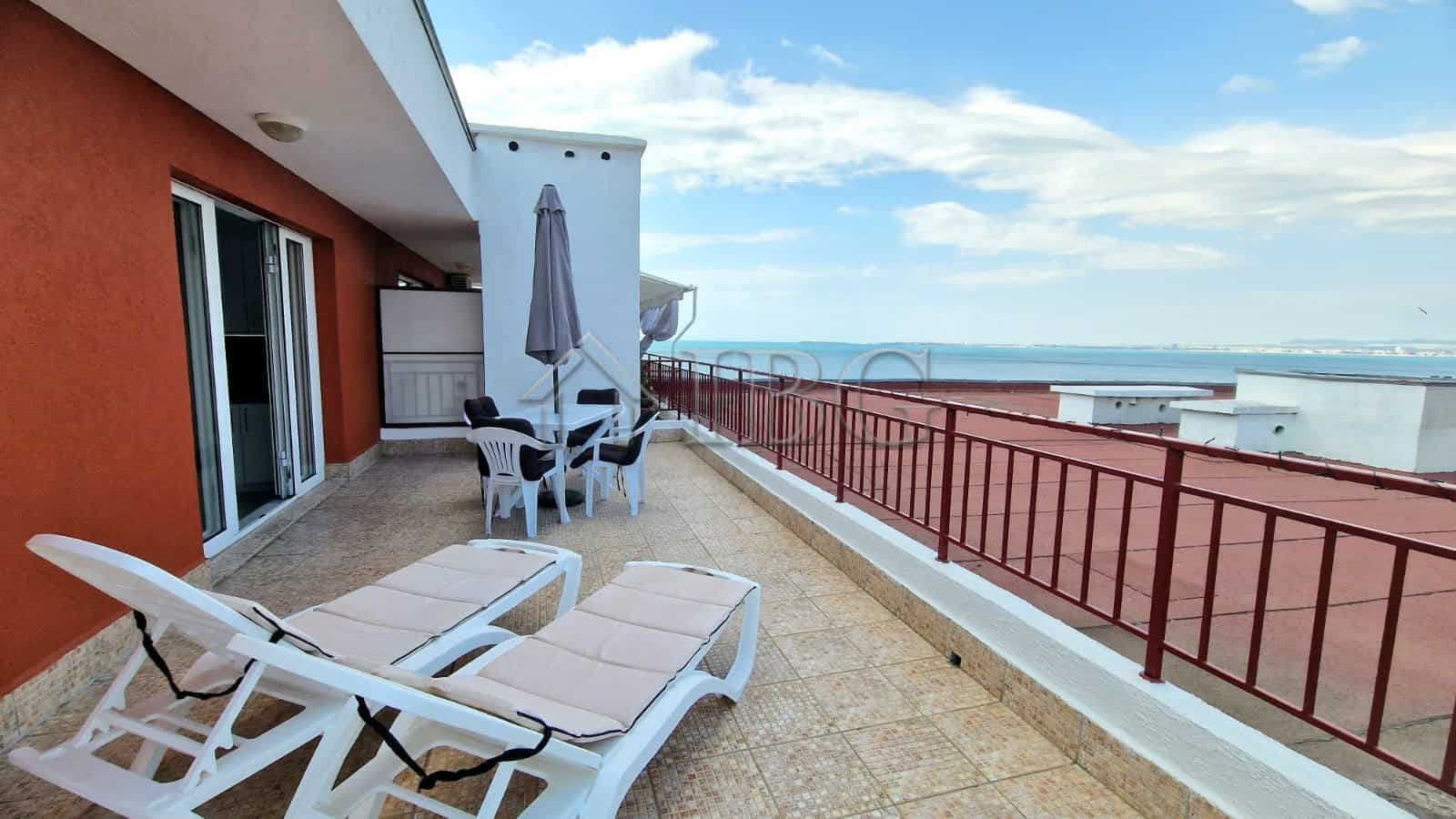 Sea view terrace of renovated apartment with outdoor furniture.