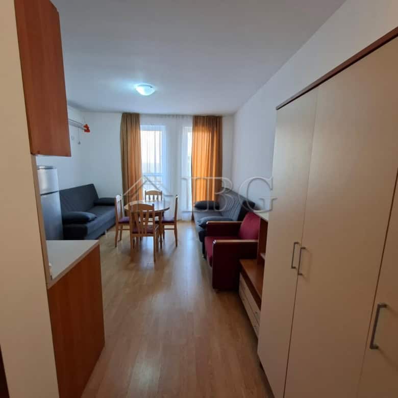 Furnished studio apartment with living area, sofa, dining table, and balcony in Sunny Beach.
