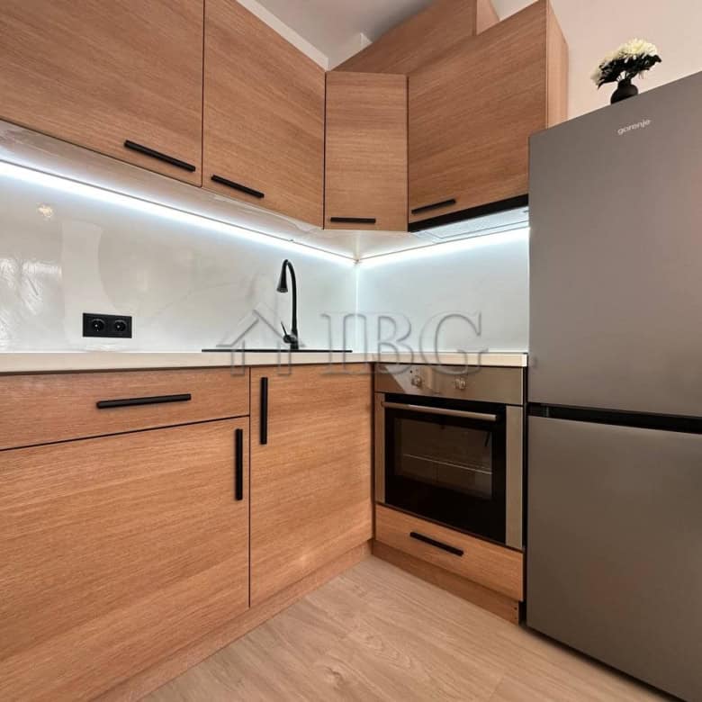 Compact kitchen with wooden cabinets, stainless steel fridge, and modern appliances in Sveti Vlas.
