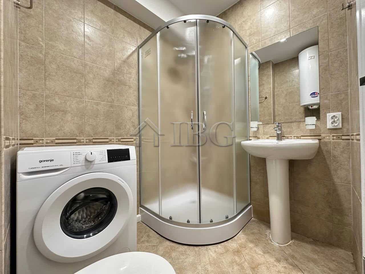 Compact bathroom with shower, washing machine, and sink in Sveti Vlas.