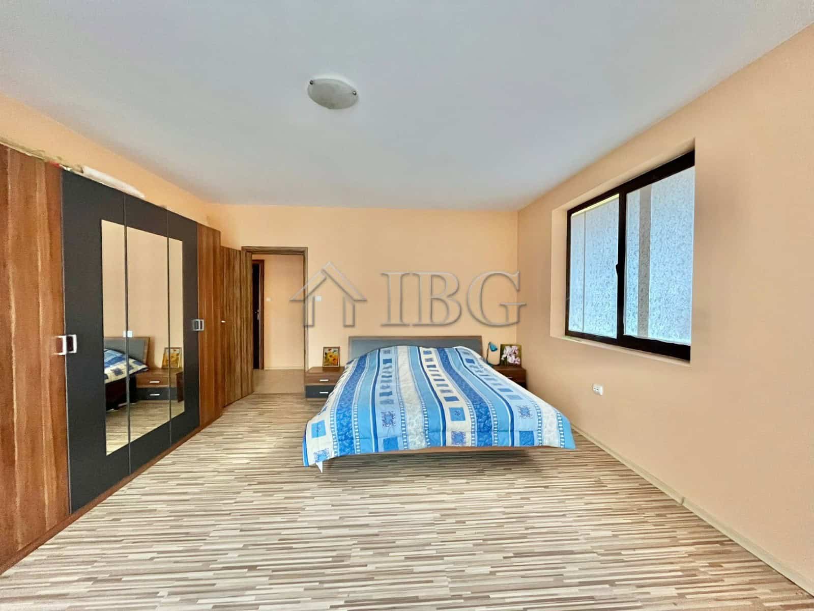 Spacious bedroom with large window and built-in wardrobe in Goritsa Village home.