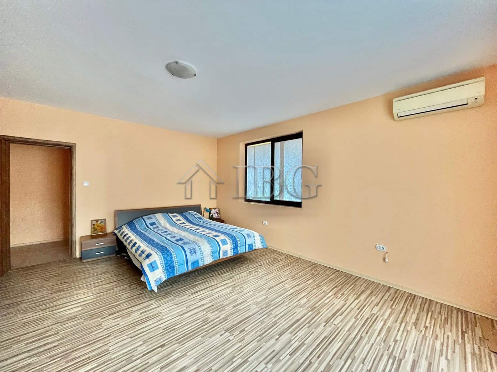 Spacious bedroom with large window and air conditioning in Goritsa Village property.