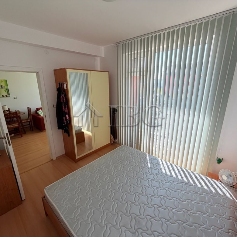 Bright 1-bedroom apartment with large window overlooking sunny beach area.