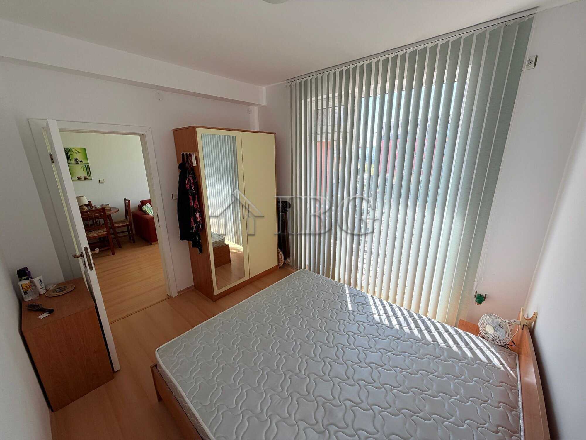 Bright 1-bedroom apartment with large window overlooking sunny beach area.