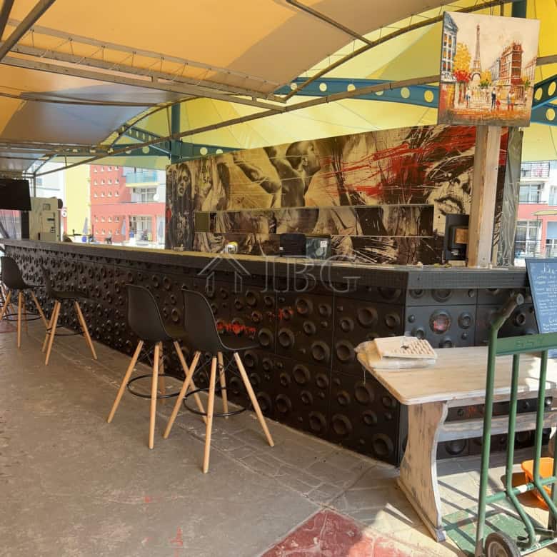 Bar counter with artistic mural and seating area at Sunny Beach, Cacao Beach.