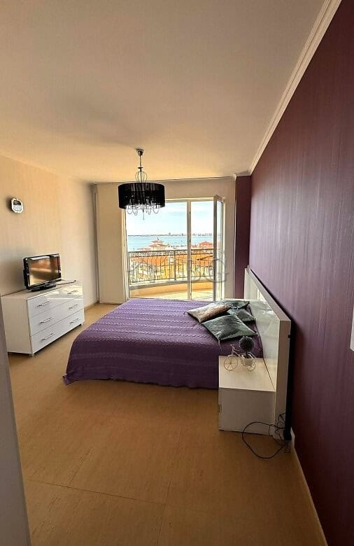 Interior of a bedroom with sea and pool view, purple bed, and modern decor in Sveti Vlas.