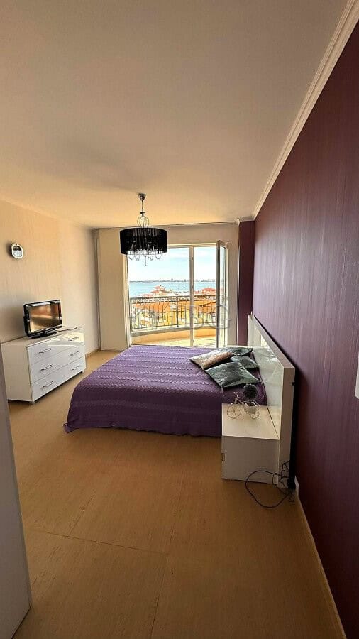 Interior of a bedroom with sea and pool view, purple bed, and modern decor in Sveti Vlas.