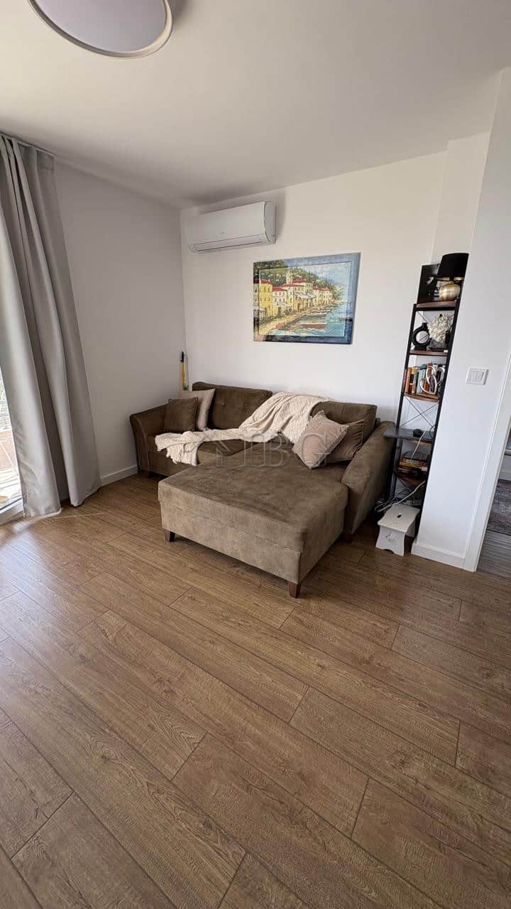 Comfortable living room with sofa, artwork, and natural light in Pomorie residence.