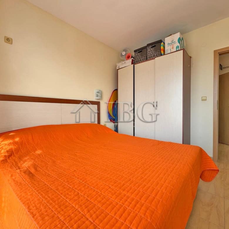 Bright bedroom with orange bedding in Aqua Dreams apartment Sveti Vlas.