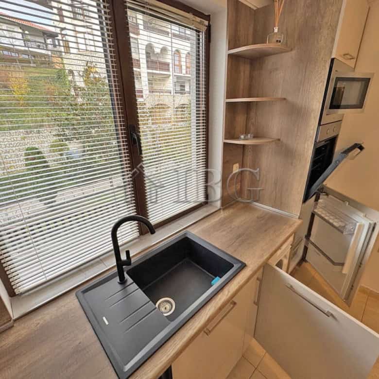 Bright studio kitchen with large window, black sink, and nearby balcony in Sveti Vlas.