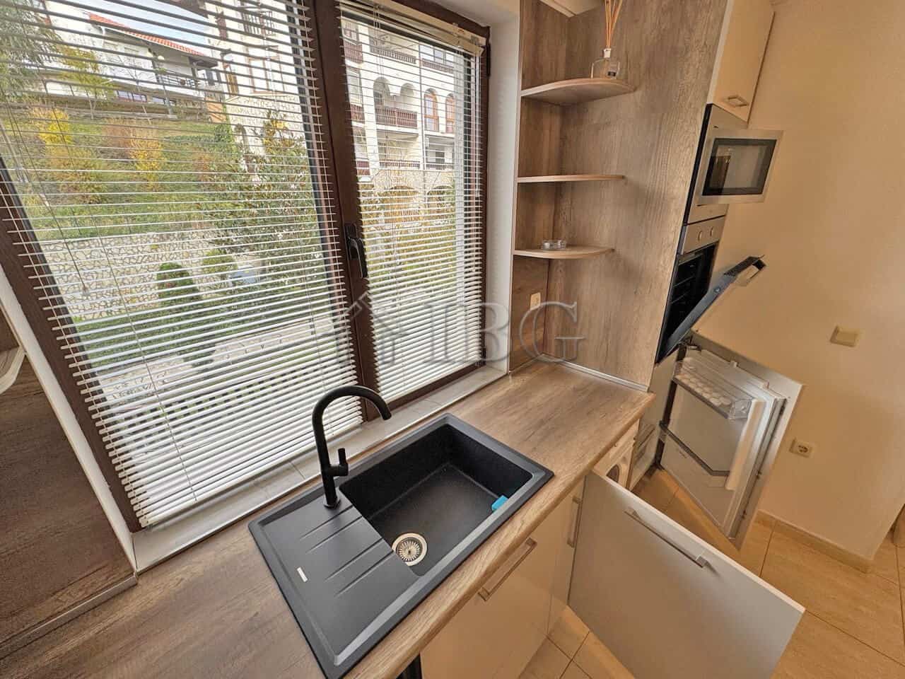 Bright studio kitchen with large window, black sink, and nearby balcony in Sveti Vlas.