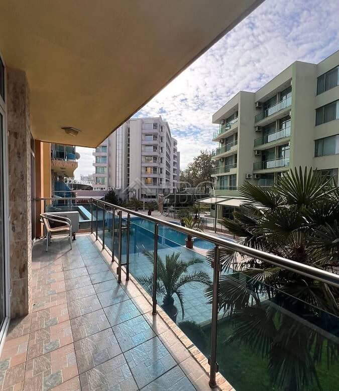 Balcony view of pool and surrounding buildings in Sunny Beach apartment complex.