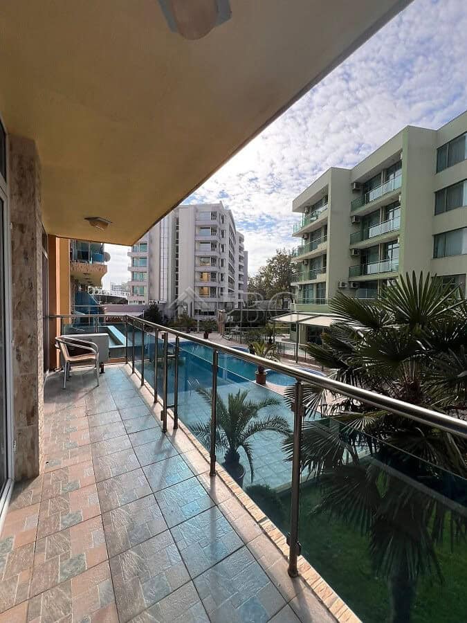 Balcony view of pool and surrounding buildings in Sunny Beach apartment complex.