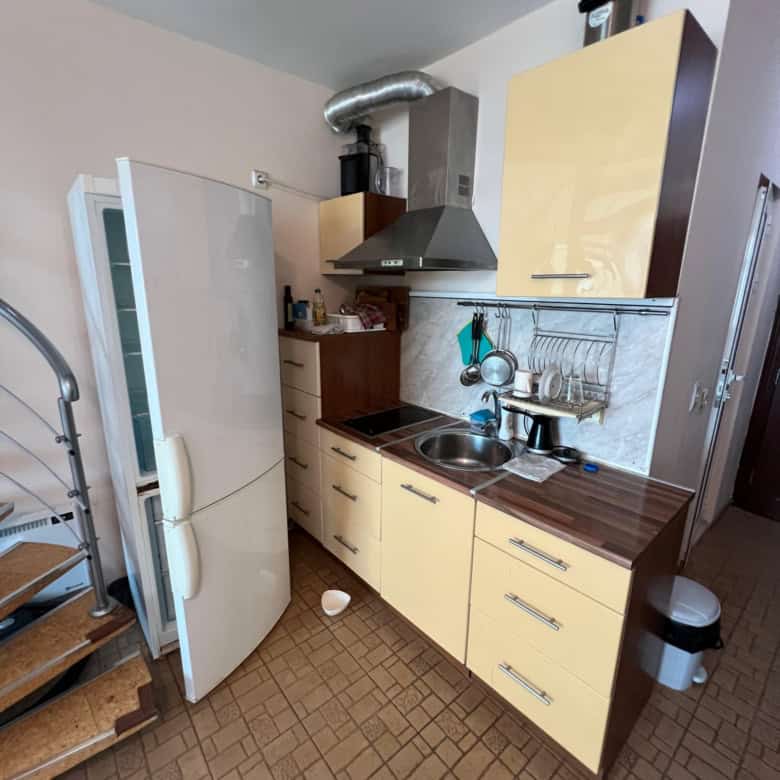 Compact kitchen with fridge, stove, and storage in Global Villa, Sunny Beach.