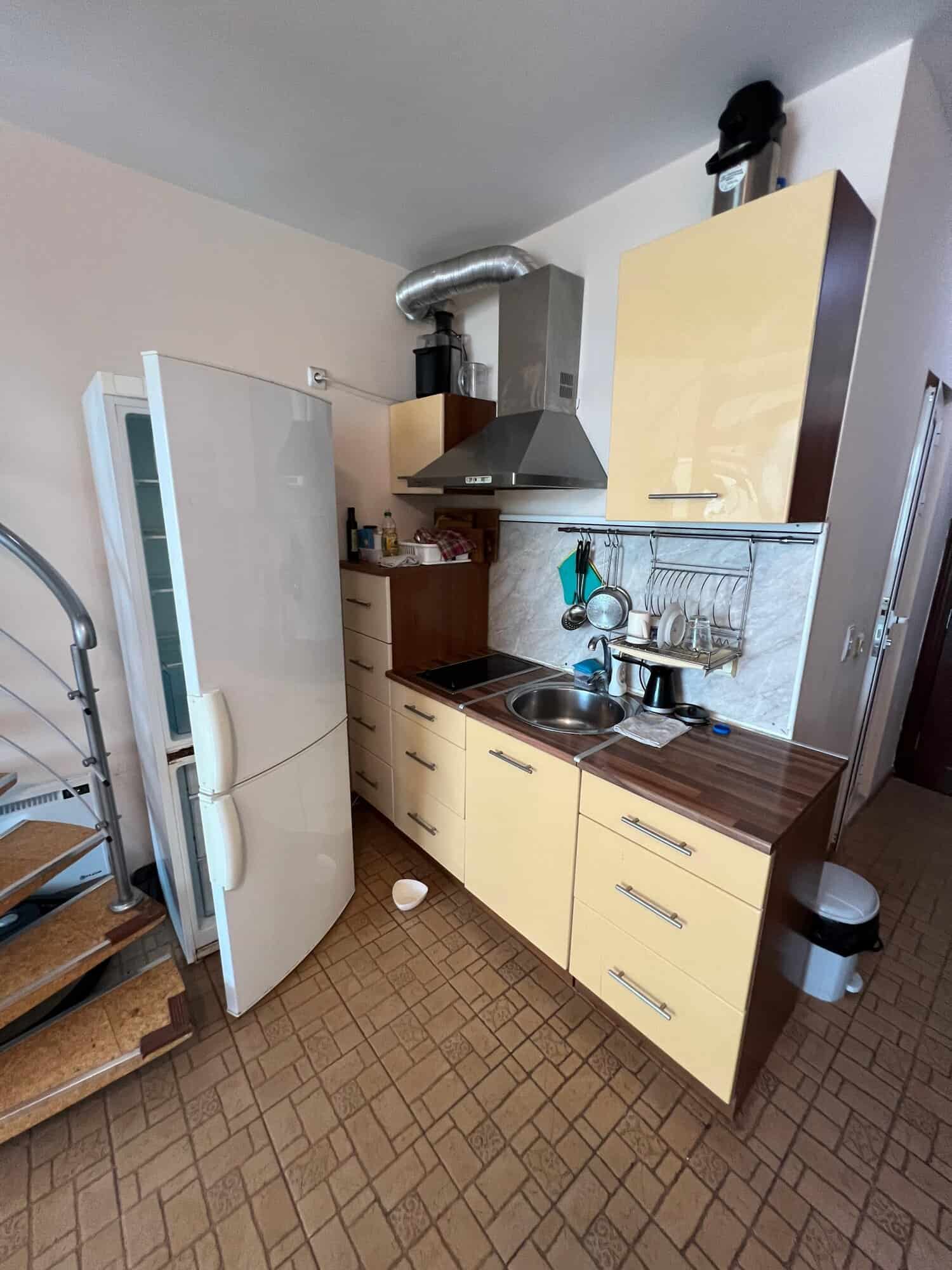 Compact kitchen with fridge, stove, and storage in Global Villa, Sunny Beach.