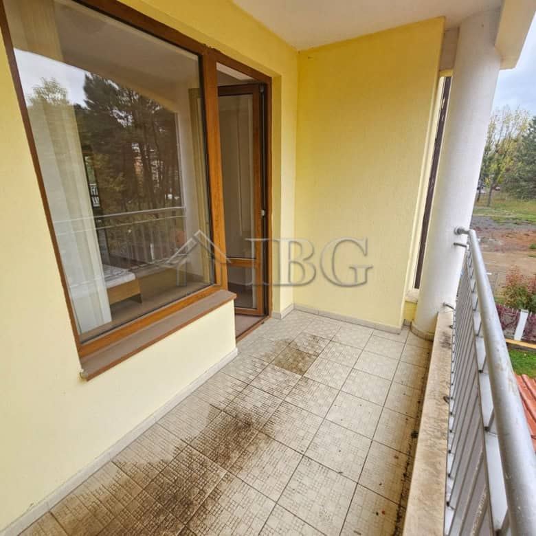 Balcony of a two-bedroom apartment overlooking the pool and surrounding nature.