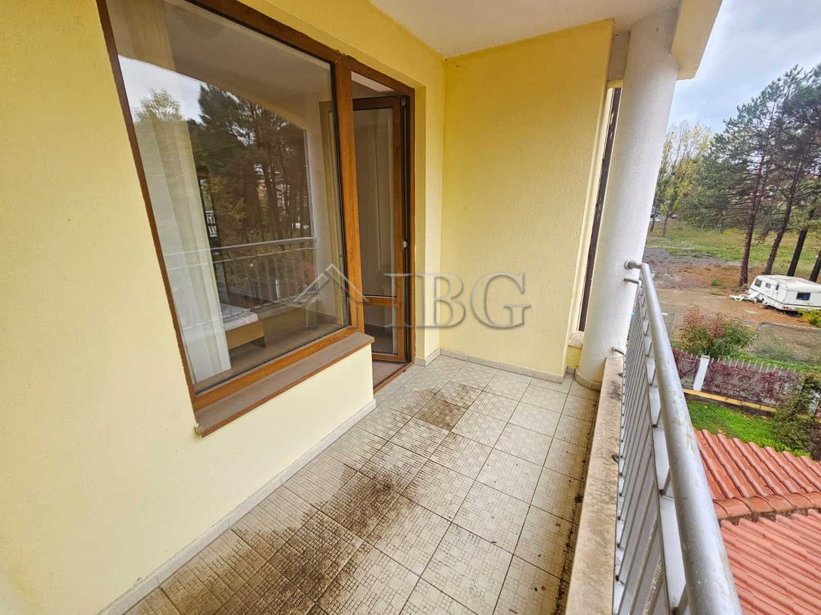 Balcony of a two-bedroom apartment overlooking the pool and surrounding nature.