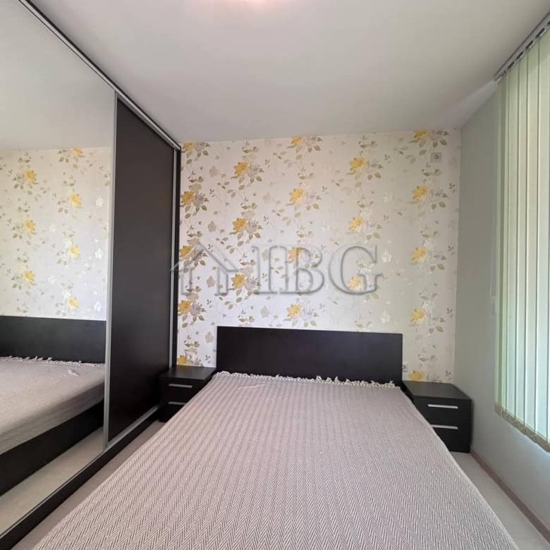 Spacious bedroom with floral wallpaper, large window, and contemporary furniture in Ravda.