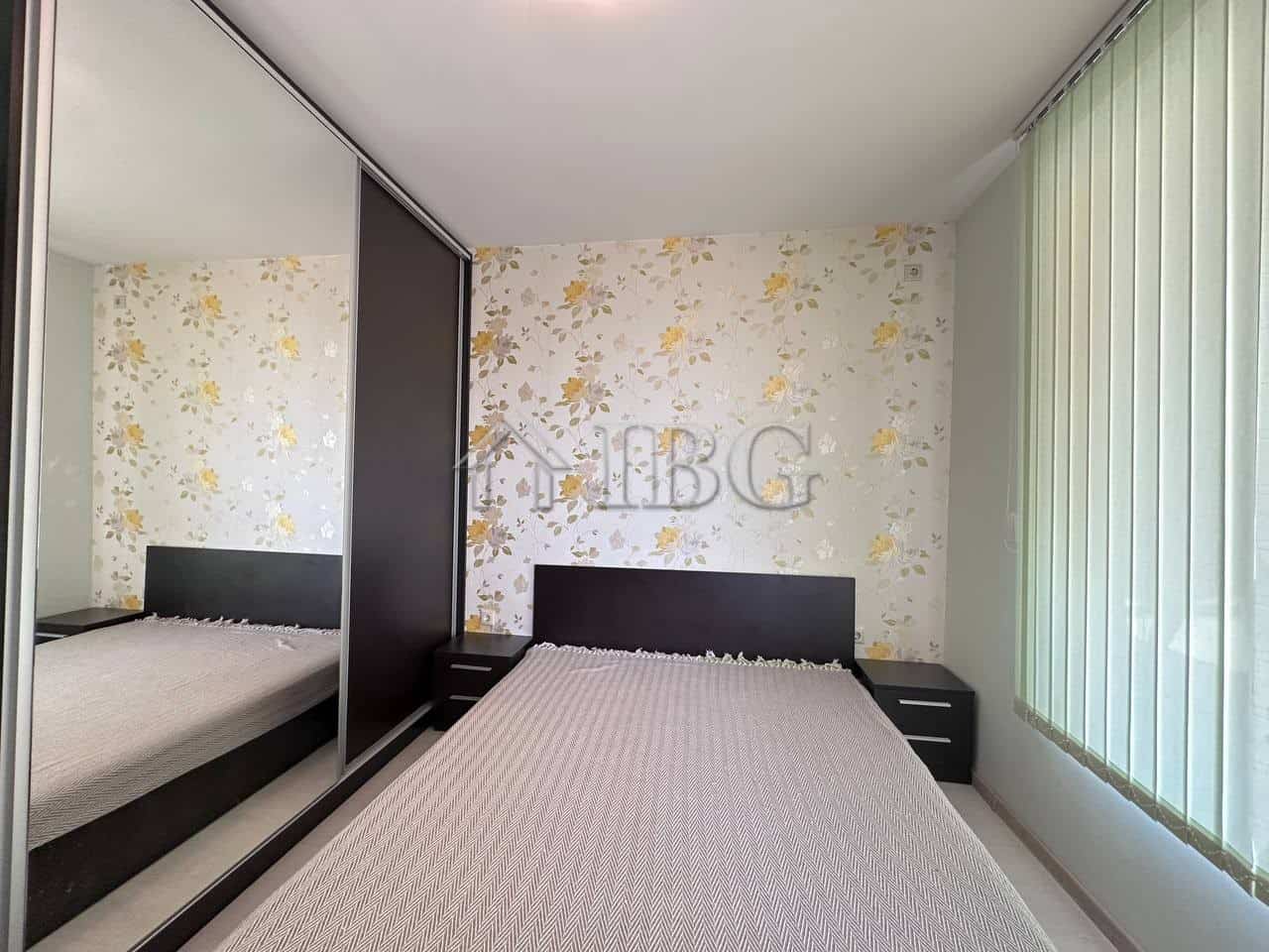 Spacious bedroom with floral wallpaper, large window, and contemporary furniture in Ravda.