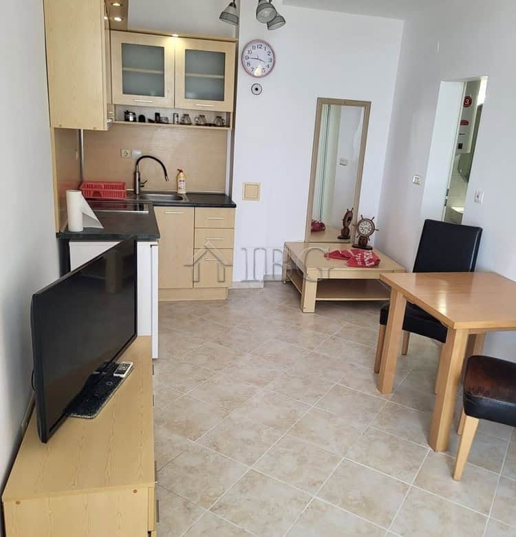 Interior view of a one-bedroom apartment with garden access, kitchen, dining area, and modern furnis.