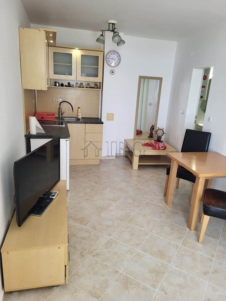 Interior view of a one-bedroom apartment with garden access, kitchen, dining area, and modern furnis.