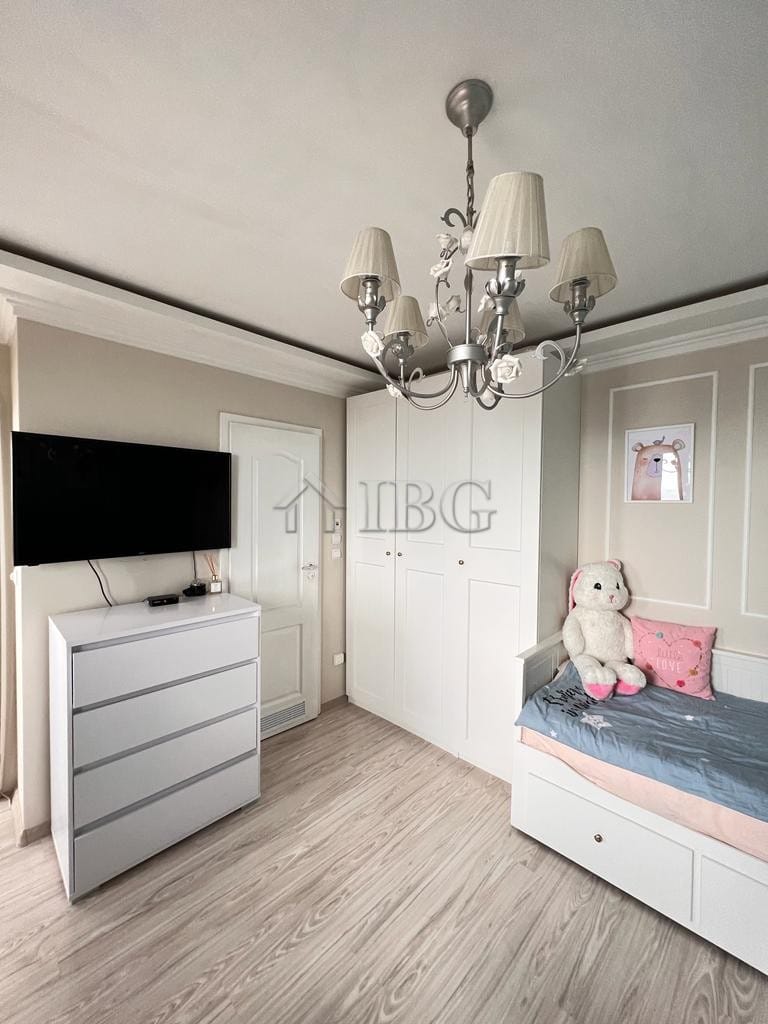Charming bedroom featuring a white wardrobe, bed, and soft decor in a seaside property.