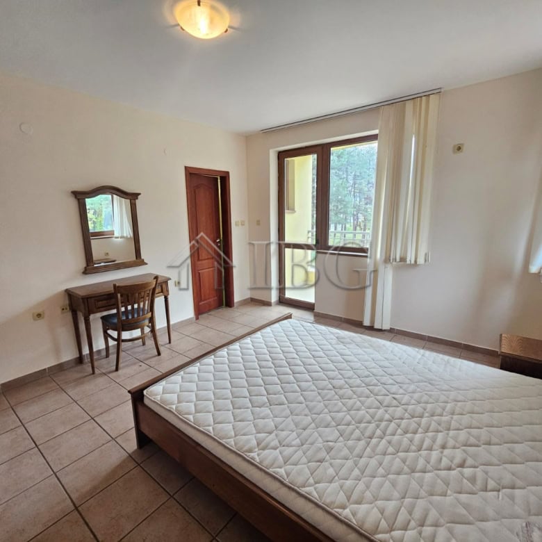 Bright bedroom with large windows overlooking the pool area.