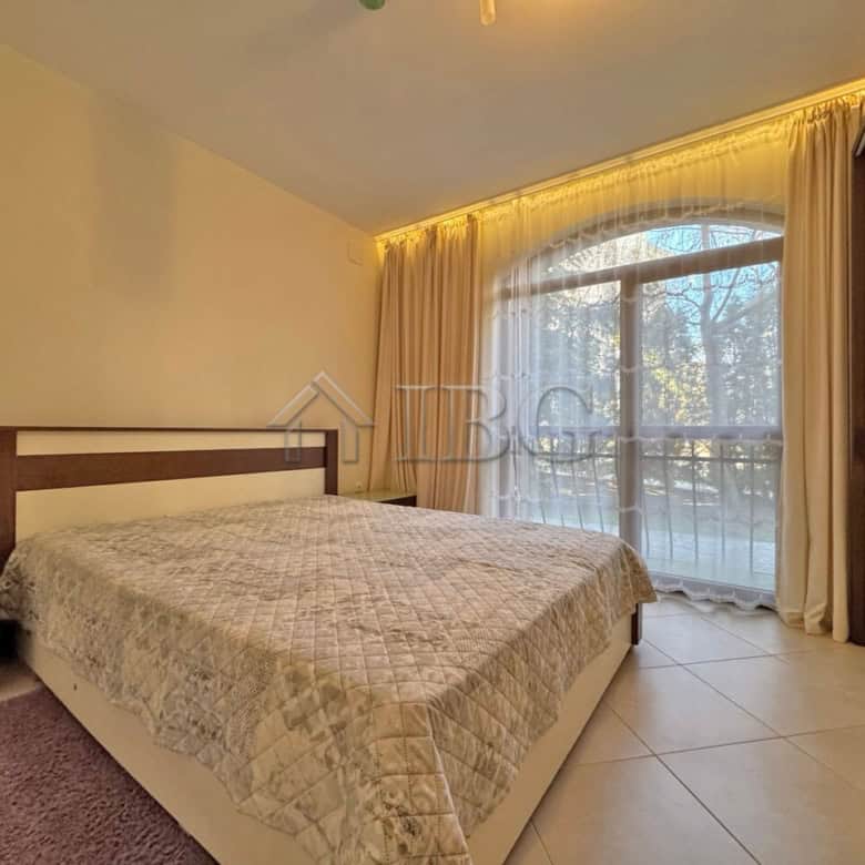 Comfortable bedroom with large window and balcony view.