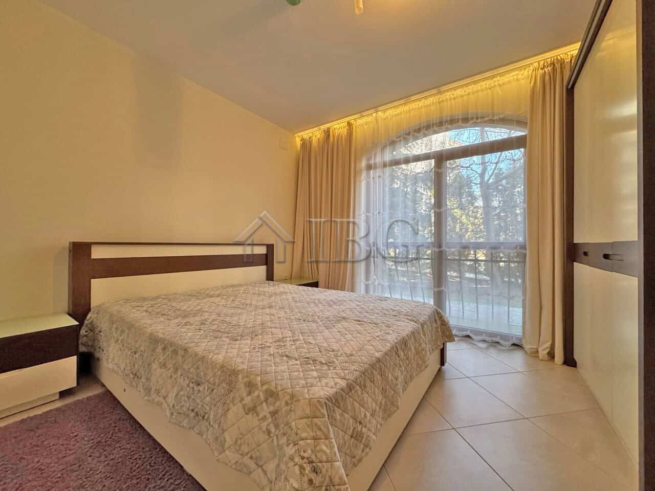 Comfortable bedroom with large window and balcony view.